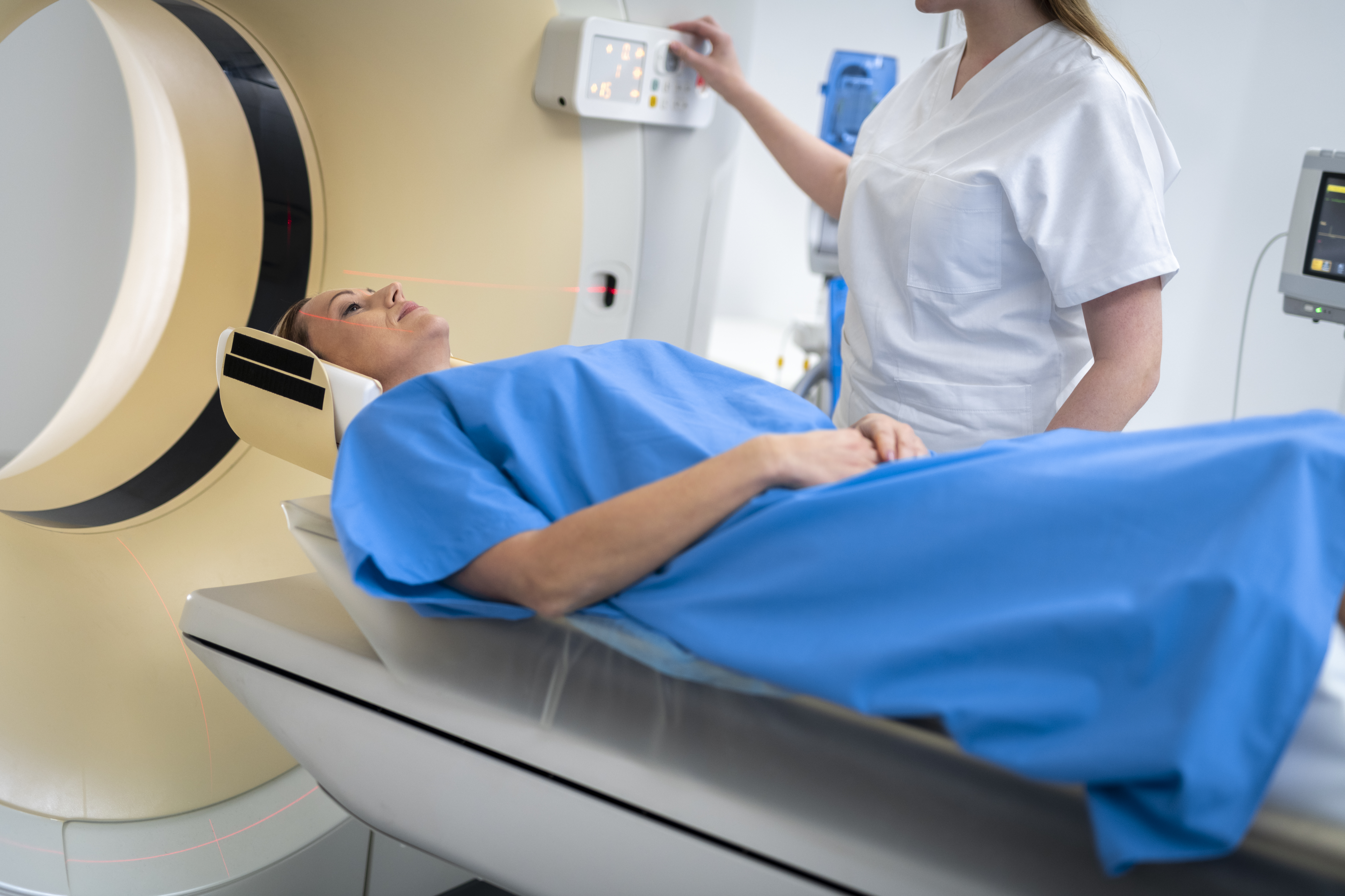 Female doctor sliding her patient into the CAT scanner