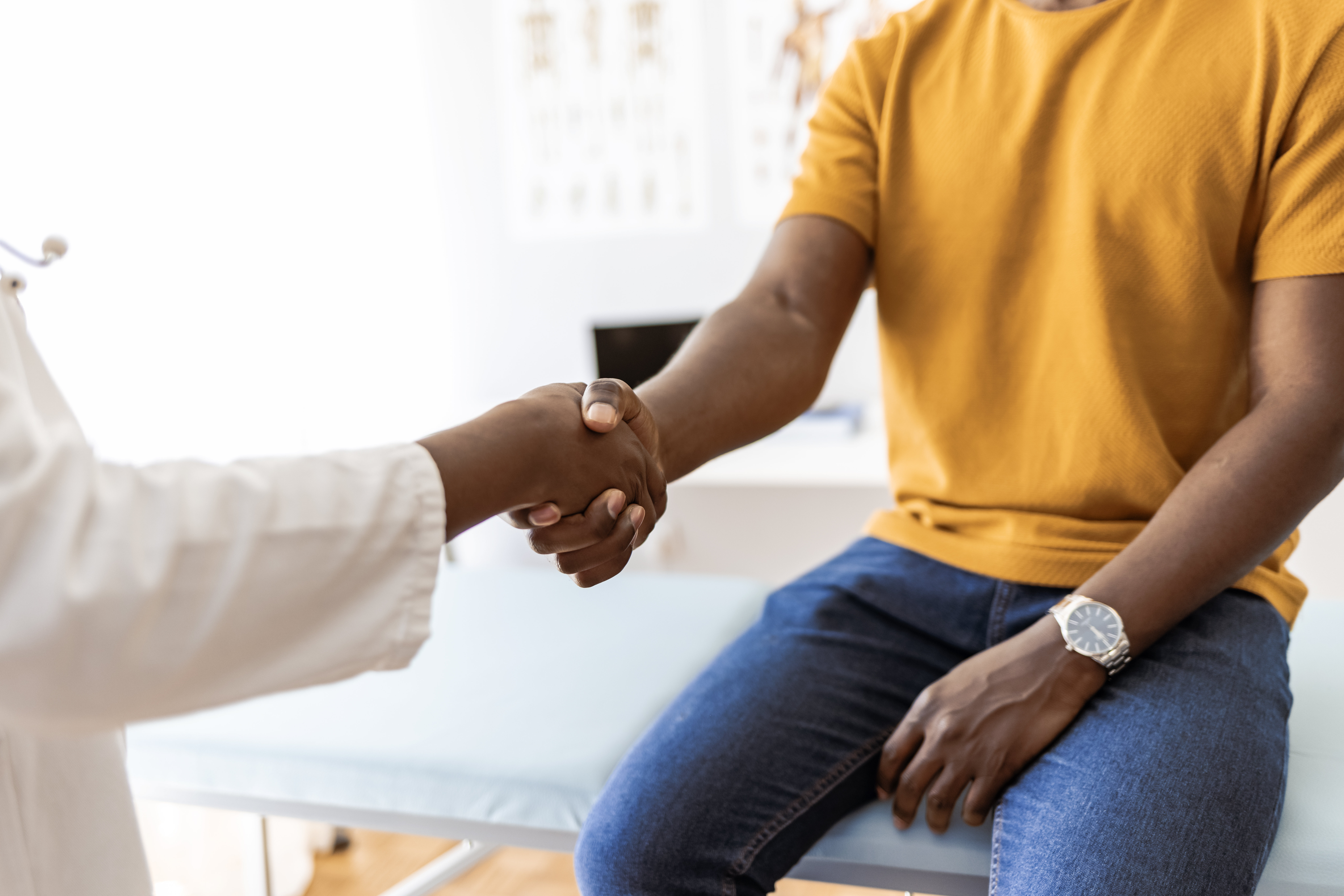 Female therapist shakes hands with new male patient